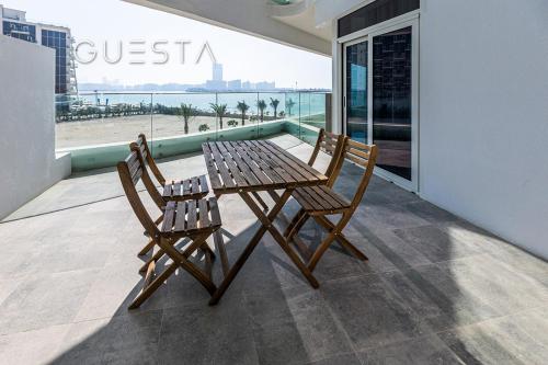 a wooden table and two chairs on a balcony at Azizi Mina The Palm, Free beach and pool access in Dubai