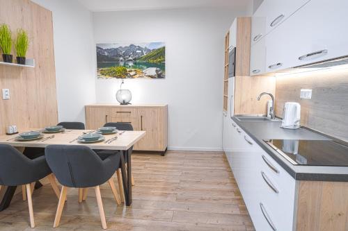 a kitchen with a table and chairs and a sink at TATRYSTAY Apartment Sankt Bernard in Nový Smokovec