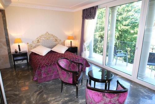 a bedroom with a purple bed and a balcony at Continental Parkhotel in Lugano