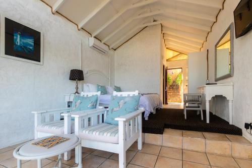 a room with two beds and a fireplace at Dutton's Cove Guest House in Herolds Bay