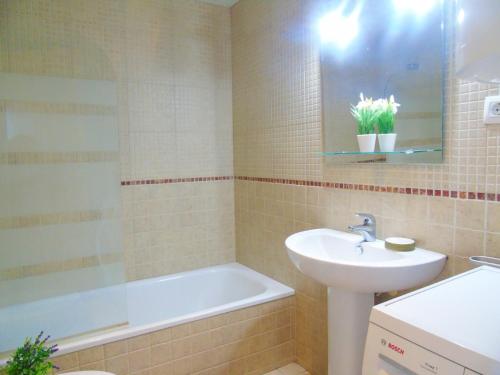 ein Badezimmer mit einem Waschbecken und einer Badewanne in der Unterkunft Bel Appartement avec Attico proche Commerces in Roses