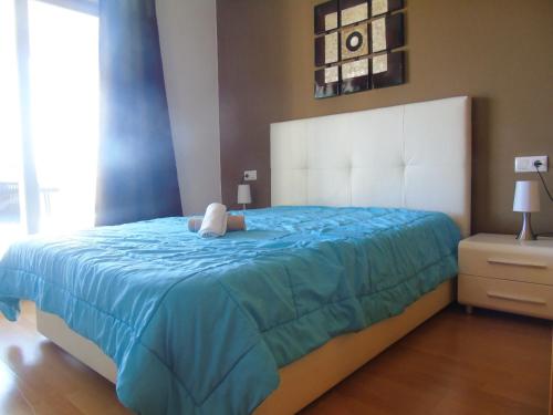ein Schlafzimmer mit einem großen Bett mit einem Teddybär darauf in der Unterkunft Bel Appartement avec Attico proche Commerces in Roses