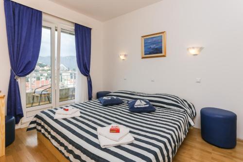 a bedroom with a bed with blue chairs and a window at K-apartments in Dubrovnik