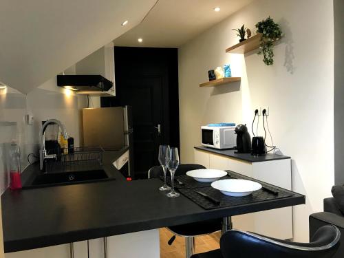 a kitchen with a black counter top in a room at Singes de la sagesse in Saint-Denis