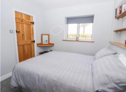 um quarto com uma cama branca e uma janela em Meadow View at Keepers Cottage em Eaton