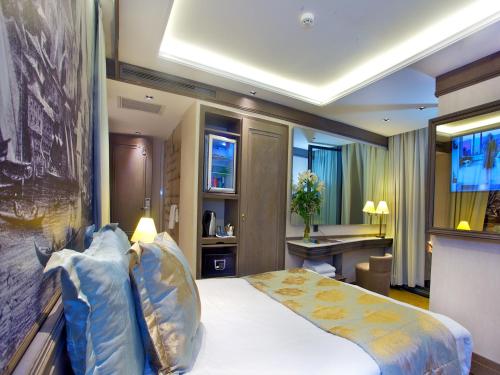 イスタンブールにあるPierre Loti Hotel Old City- Special Categoryのベッドとデスクが備わるホテルルームです。