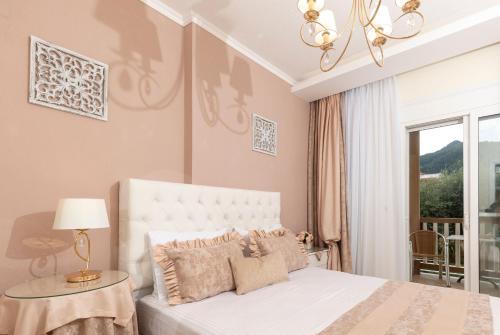 ein Schlafzimmer mit einem weißen Bett und einem Kronleuchter in der Unterkunft San Giorgio Apartments in Skala Potamias