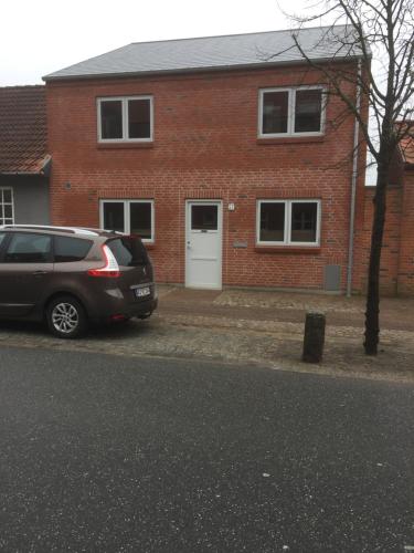 a car parked in front of a brick house at Bramming city privat gæstehus in Bramming