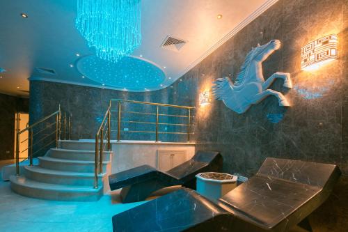 a lobby with a staircase with a blue ceiling and a stair case at Atli Hotel Ankara in Ankara
