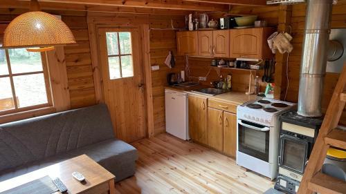 una cocina con fogones y un sofá en una cabaña en Nature Getaway Holiday Home, en Mujaste