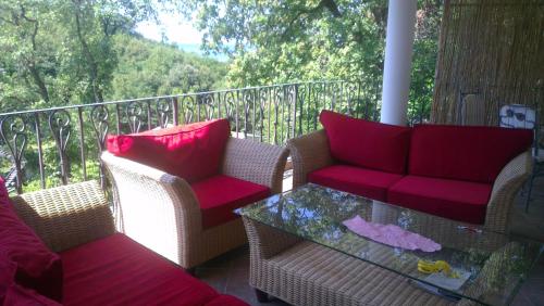 a balcony with two chairs and a glass table at Holiday House Villa Neda in Utjeha