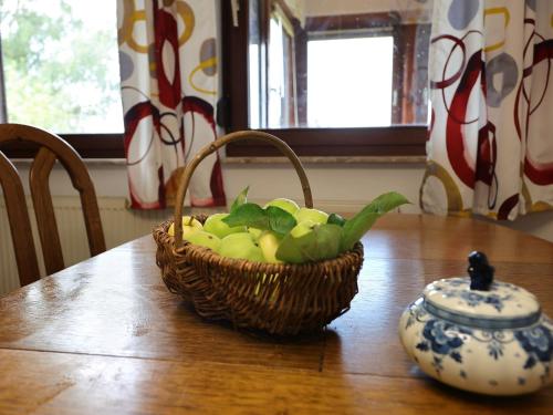 einen Obstkorb auf einem Holztisch mit einer Vase in der Unterkunft Ferienwohnung Landleben in Hofgeismar
