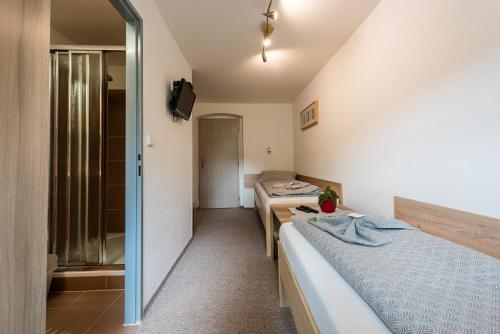 a room with two beds and a bathroom at Penzion 103 in Železná Ruda