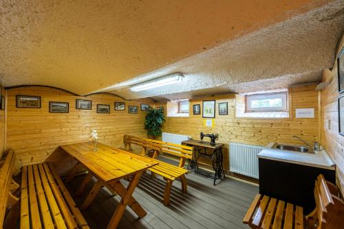 a room with benches and a table and a sink at Penzion 103 in Železná Ruda