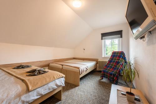 a small room with two beds and a tv at Penzion 103 in Železná Ruda