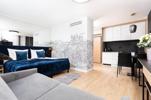 a bedroom with a bed and a kitchen with a table at InPoint Central Apartments in Kraków