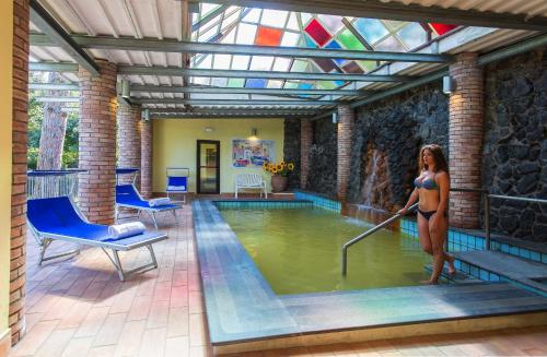 a woman is standing in a pool of water at Hotel San Valentino Terme in Ischia