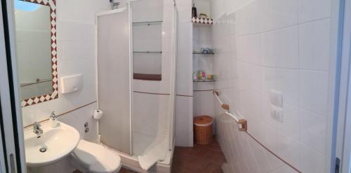 Baño blanco con aseo y lavamanos en B&B Chianalea 54, en Scilla