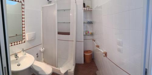 a white bathroom with a toilet and a sink at B&B Chianalea 54 in Scilla