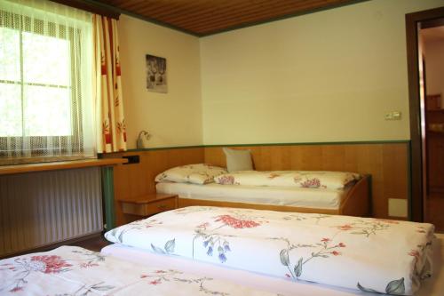 - 2 lits dans une chambre avec fenêtre dans l'établissement Appartement Gleiminger, à Forstau