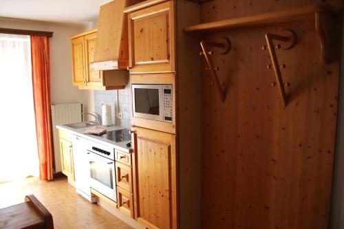 cocina con armarios de madera y microondas en Appartement Gleiminger en Forstau