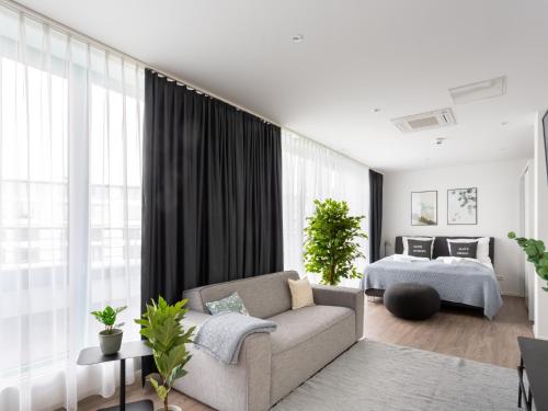 uma sala de estar com um sofá e uma cama em limehome Köln Friesenplatz - Digital Access em Colônia