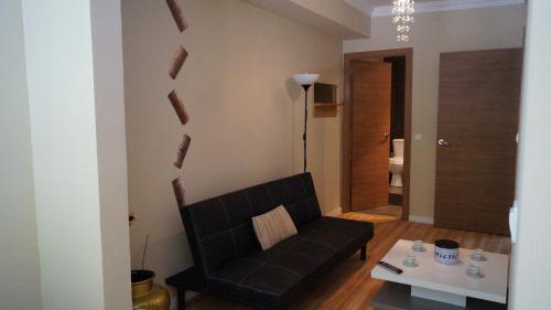 sala de estar con sofá negro y mesa en Good-Home Paseo de Gracia, en Barcelona
