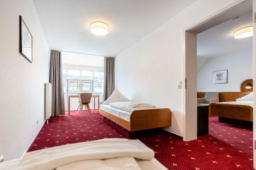 a hotel room with two beds and a mirror at Hotel & Gasthaus Löwen in Waldkirch