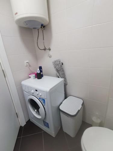 a small bathroom with a washing machine and a toilet at Apartman Natasa in Karaburma