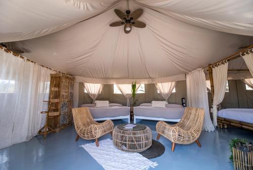 a room with two beds and a table and chairs at El Toril Glamping Experience in Parrillas