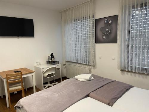 een slaapkamer met een bed, een bureau en een televisie bij Hotel-Kronenhof in Jülich