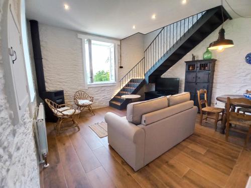 a living room with a couch and a staircase at Apartamentos Minas de Silvarosa in Viveiro