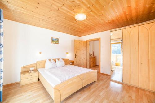 a bedroom with a bed and a wooden ceiling at Egarthof Ferienwohnung Alpenrose in Moso