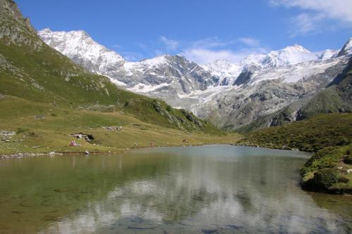 a mountain lake with snow capped mountains in the background at Polaris 1 001 - LUXE & SKI LIFT apartment 6 pers in Zinal