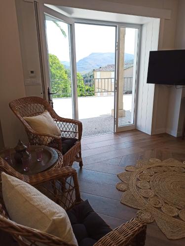 a living room with wicker chairs and a large sliding glass door at Apartamentos Minas de Silvarosa in Viveiro