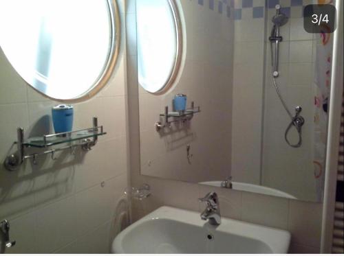 La salle de bains est pourvue d'un lavabo et d'un miroir. dans l'établissement Le Stanze sul Po, à Ferrare