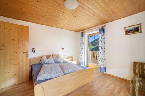 a bedroom with a bed with a wooden ceiling at Egarthof Ferienwohnung Enzian in Moso