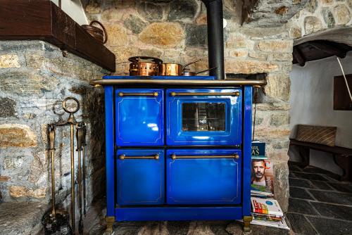 a blue cabinet with a stove in a room at Casa Alma Grotto in Brione sopra Minusio