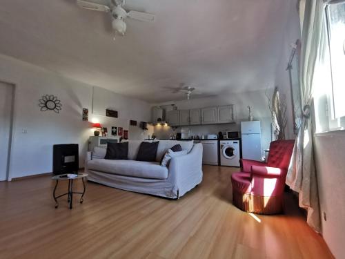 a living room with a white couch and a kitchen at HERDADE PALMA t1 in Moita