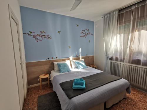 マルゲーラにあるBeautiful Venice B&Bのベッドルーム(青い枕の大型ベッド1台付)