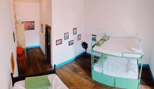 a room with two bunk beds and a hallway at Del Mundo Hostel in São João del Rei