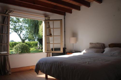 une chambre avec un lit et une grande fenêtre dans l'établissement La Bastide, à Lagrange