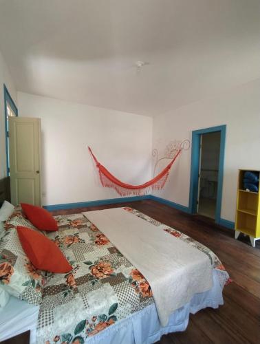 a bedroom with a bed with red pillows on it at Del Mundo Hostel in São João del Rei