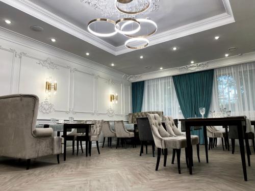 a dining room with tables and chairs and a chandelier at Park Hotel Fili in Moscow