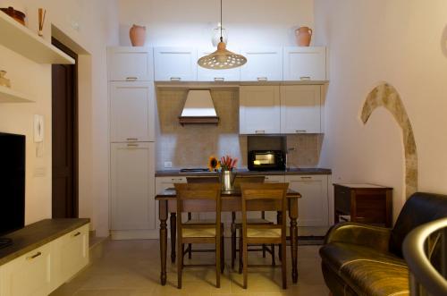 a kitchen and living room with a table and a couch at ANTICA CASA TRECENTESCA in Altamura