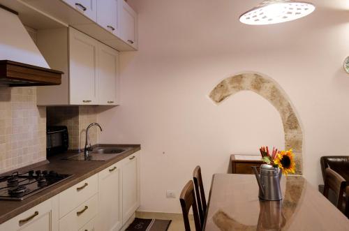a kitchen with a table and an arch in the wall at ANTICA CASA TRECENTESCA in Altamura