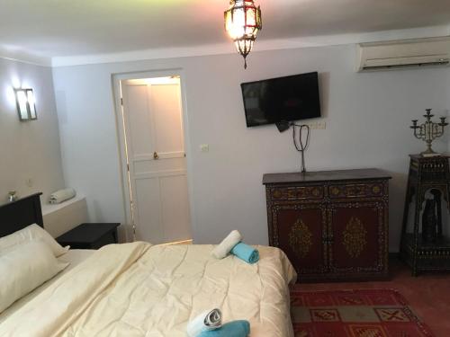 a bedroom with a bed and a tv on the wall at Dar el Koutoubia in Marrakech