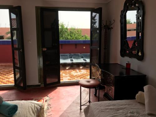 a bedroom with a bed and a mirror and a chair at Dar el Koutoubia in Marrakech