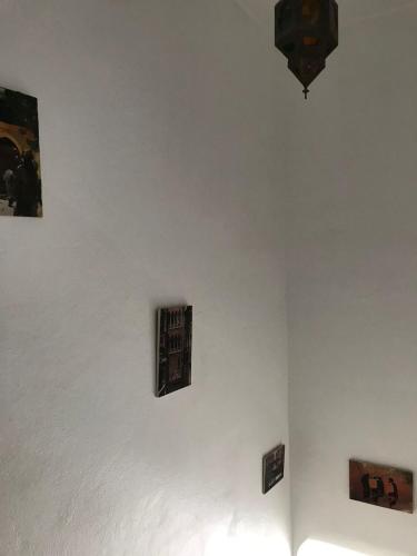 a white wall with three pieces of art on it at Dar el Koutoubia in Marrakech