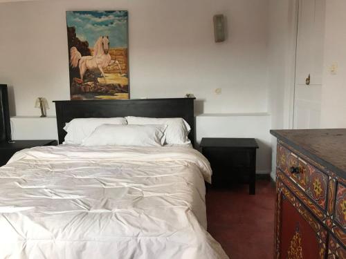 a bedroom with a bed and a painting on the wall at Dar el Koutoubia in Marrakech